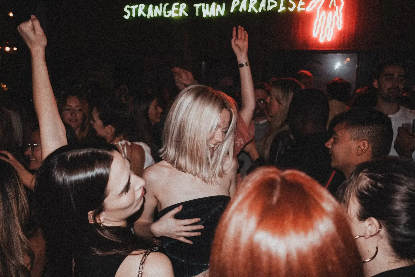Personas bailando bajo los focos de un concierto